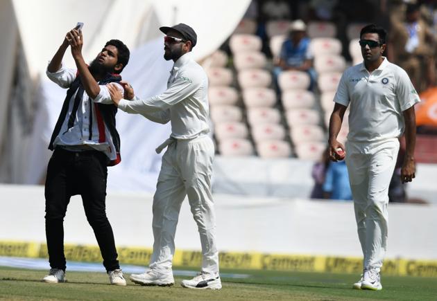 A cricket fan (L) enters the pitch to take a selfie and hug Indian cricket captain Virat Kohli (C) during the first day's play of the second Test cricket match between India and West Indies at the Rajiv Gandhi International Cricket Stadium in Hyderabad (AFP) A cricket fan (L) enters the pitch to take a selfie and hug Indian cricket captain Virat Kohli (C) during the first day's play of the second Test cricket match between India and West Indies at the Rajiv Gandhi International Cricket Stadium in Hyderabad (AFP)
