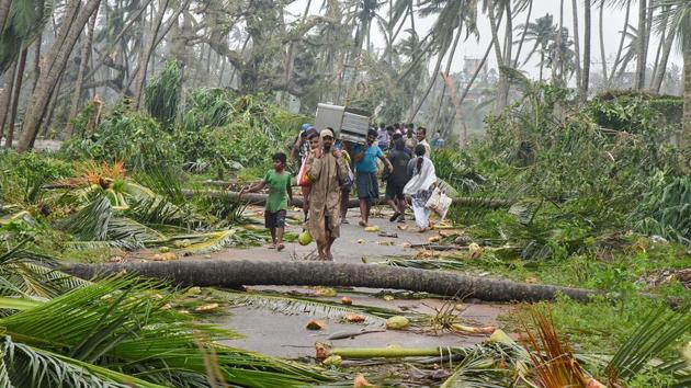 A group of people relocating to safer places after Cyclone Titli hits Barua village, in Srikakulam, on Oct 11, 2018.(PTI)