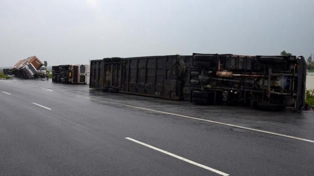 Overturned trucks are pictured on a highway after cyclone Titli hit in Srikakulam district, Andhra Pradesh. (Stringer / REUTERS)