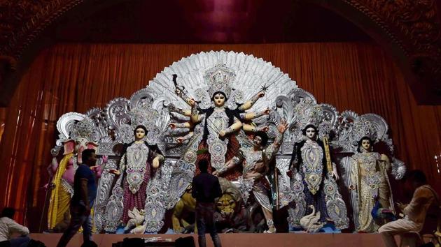 Artists give finishing touches to idols of deities at a Durga Puja pandal, in Kolkata, Thursday, Oct 11, 2018. The SC has refused to stay Bengal government decision to grant <span class='webrupee'>₹</span>10,000 each to 28,000 Durga Puja committees in the state.(AP)