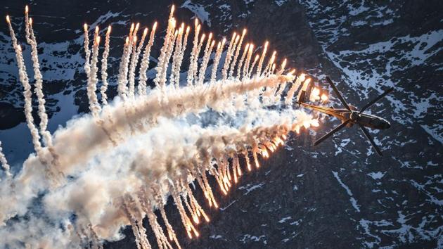 A Super Puma Cougar helicopter releases flares over Brienz in the Bernese Alps, during the annual live fire event of the Swiss Air Force at the Axalp. (Fabrice Coffrini / AFP)