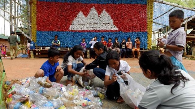 Located in a lush national park, the Coconut School is built almost entirely from recycled waste and is the brainchild of Ouk Vanday. About 65 kids are enrolled at the school, where classroom walls are made of painted car tyres and the entrance adorned with a mural of the Cambodian flag made entirely from bottle caps. Most of that garbage came from students in the form of school fees. (Tang Chhin Sothy / AFP)
