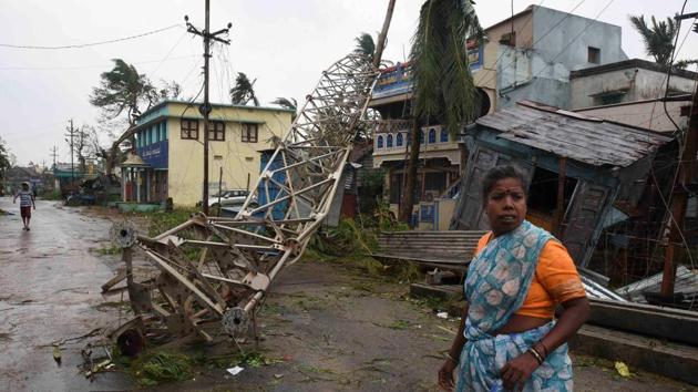 A woman stands next to a damaged communication tower after cyclone Titli hit in Srikakulam district in Andhra Pradesh, October 11, 2018.(Reuters)