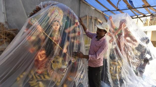 From the mixing of the soil, to the last touches of beautifying the idol, he does it all. After adding the final touches, the craftsman covers the idol to keep it safe before delivering it to his customers. (Sanjeev Verma / HT Photo) 