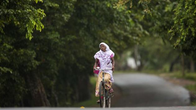 An Assamese woman in traditional attire rides a bicycle in Kaziranga, Assam. The area is famous for the Kaziranga National Park which has the world’s largest concentration of Indian one-horned rhinoceros. (Anupam Nath / AP)