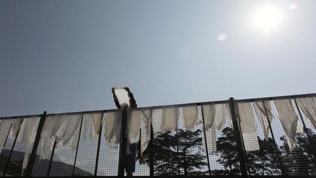 A Tibetan student puts washed ceremonial scarves called khatag out to dry at the Tibetan Children’s Village School in Dharmsala, Himachal Pradesh. The school, which started as an orphanage in 1960, houses and educates over a thousand refugee children. (Ashwini Bhatia / AP)