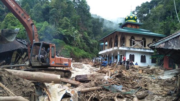 People use a heavy equipment to remove debris after flash floods hit the Saladi village in Mandailing Natal, North Sumatra on October 13, 2018. (AFP Photo) People use a heavy equipment to remove debris after flash floods hit the Saladi village in Mandailing Natal, North Sumatra on October 13, 2018. (AFP Photo)