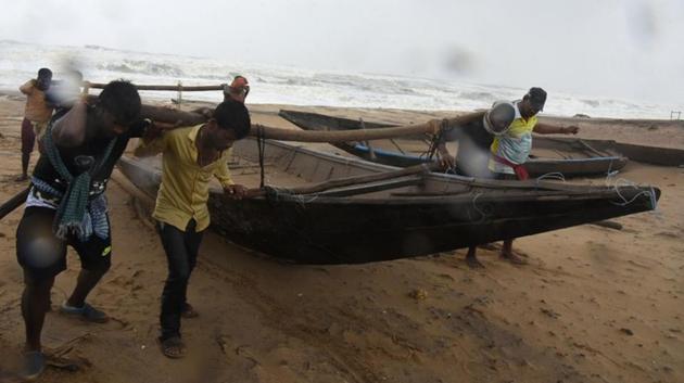 People move a boat to a safer place along the shore as Cyclone Titli makes landfall at Gopalpur, in Ganjam district, Odisha. (Stringer / REUTERS)