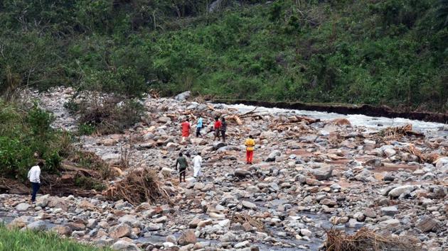 Local people watch the recovery of dead bodies at the foothill stream near Baraghar under Rayagada block of Gajapati district of Odisha, where 16 persons died in a rockslide in the aftermath cyclonic storm Titli.(Arabinda Mahapatra/HT)