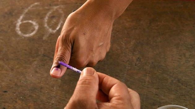 The semi-permanent ink is applied to the forefinger of electors to prevent them from voting more than once under rules mandated by the ECI . The stain lasts several days before starting to fade.(AP File Photo)