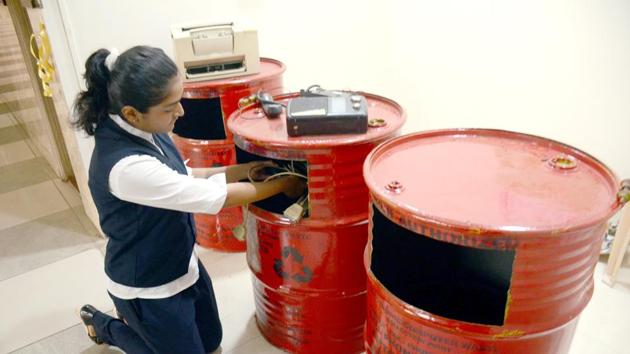 A school student puts e-waste in a drum to be reused on International E-Waste Day at Sadhu Vaswani International School Sanpada in Navi Mumbai.(HT Photo)