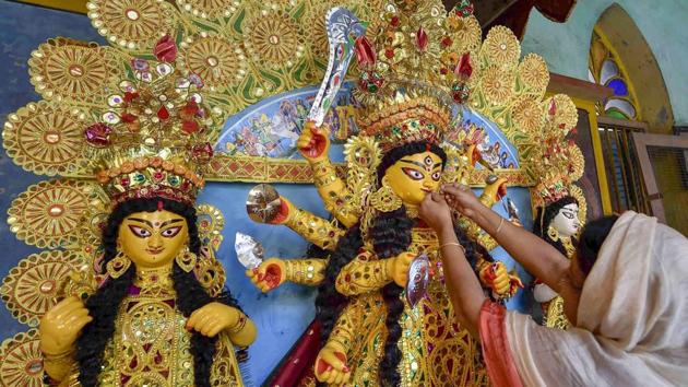 An idol of Goddess Durga being decorated with gold ornaments at a traditional 189 years old puja house on Mahashasthi, indicating the beginning of the Durga Puja festival, in Kolkata. (Ashok Bhaumik / PTI)