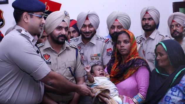 SSP Sandeep Garg hands over the child to his parents in Sangrur on Tuesday. (HT Photo) SSP Sandeep Garg hands over the child to his parents in Sangrur on Tuesday. (HT Photo)