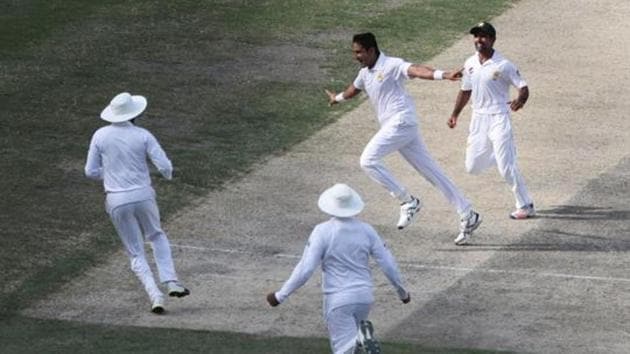 Pakistani cricketer Muhammad Abbas (C) celebrates with teammates after taking a wicket.(AFP)