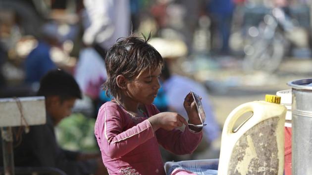 A child pours out melted ice-cream from a bowl onto a spoon on the outskirts of Jammu. Some 821 million people, or one of every nine people on the planet, suffered from hunger last year, marking the third consecutive annual increase, according to the UN’s latest hunger report.(AP Photo)