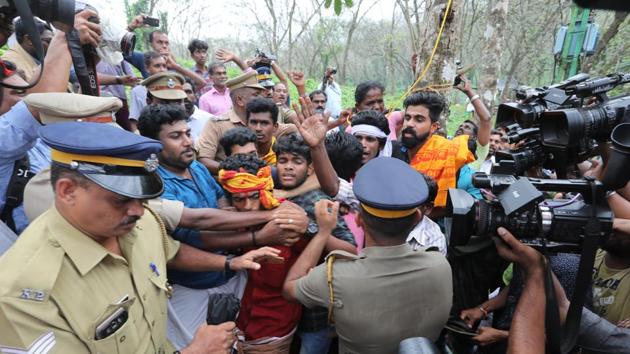 Police personnel tackling devotees protesting against the entry of women of all ages to the Sabarimala temple, at Nilakkal base camp in Pathanam, Kerala, on Tuesday.(Vivek Nair/HT Photo)