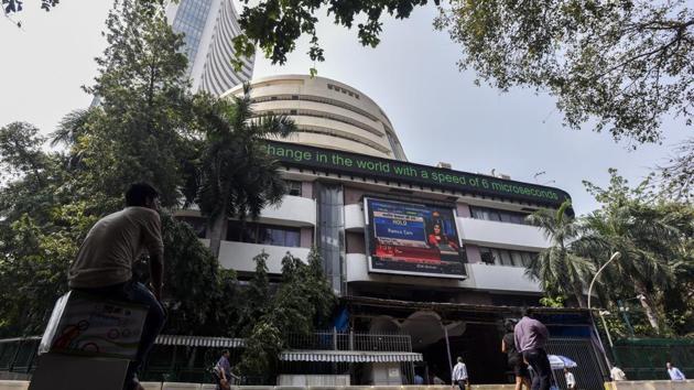 People watch share prices on a digital broadcast outside the Bombay Stock Exchange (BSE) in Mumbai on October 11.(Kunal Patil/HT Photo)