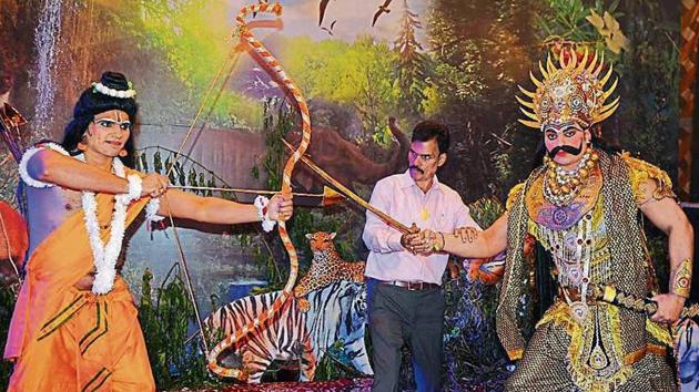 Mohit Kumar donning the role of Ram engaged in a duel with his brother Rohit Kumar as Ravana, as their father Pradeep Kumar looks on at Navyug Ramlila in Sector 7, Chandigarh.(HT Photo)