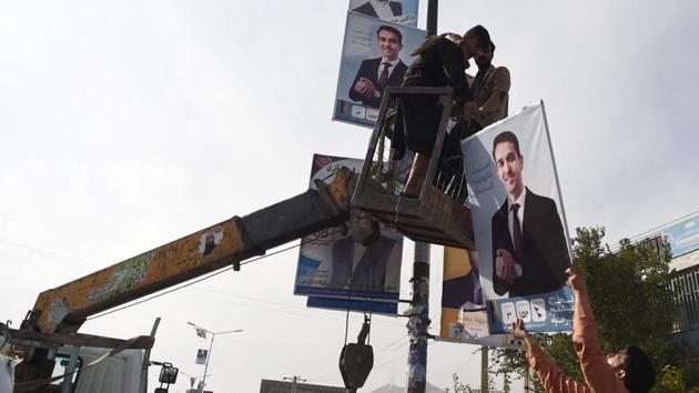 Afghan labourers hang banners of candidate Alhaj Abdull Qayoum Khairkhah on a post along the street during the legislative election campaign in Kabul on October 15, 2018. (AFP) Afghan labourers hang banners of candidate Alhaj Abdull Qayoum Khairkhah on a post along the street during the legislative election campaign in Kabul on October 15, 2018. (AFP)