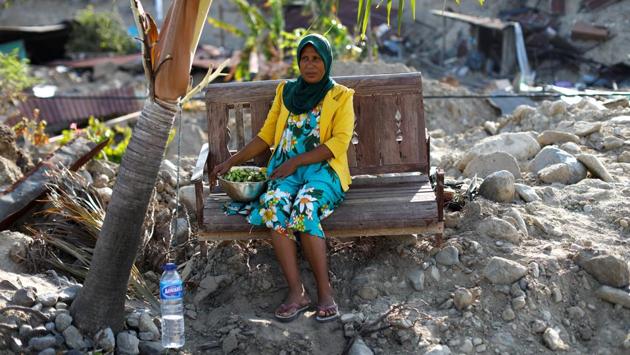 Masdiyana, 47, sits on a bench of her mother's former home which was destroyed during the earthquake in Balaroa neighbourhood, Palu. Masdiyana has been trying to salvage items from her mother's home, picking vegetables and fruit from the garden. (Jorge Silva / REUTERS)