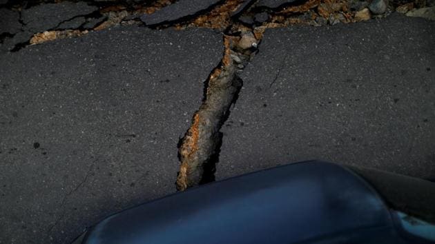A car stands next to a road that was upended by the earthquake and ground liquefaction. Searchers arrived with dozens of excavators to help dig out bodies, while some residents made frequent trips to retrieve treasured belongings from the rubble of destroyed homes. (Jorge Silva / REUTERS)