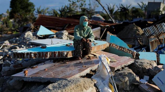 Hesti Andayani, 27, sits on a pile of tiles that used to be part of her second-floor bedroom. Andayani lost her younger sister in the quake. Returning to Balaroa for the first time, nearly two weeks later, she was shocked to find that her childhood home had slid far downhill. "It took so long for me to find it," she said, through tears. "I don't know where we can live now." (Jorge Silva / REUTERS)