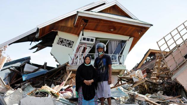 Darmi, 48, and her brother Rusli, 43, outside her house. The destructive waves of soil smashed homes, cars and buildings into each other, carrying some hundreds of metres from their original position. “It felt like the earth was alive,” said Darmi, who saw half of her home collapse. “It was opening up, swallowing people, and then closing again. And the noise was so loud. This loud cracking ‘k-k-k-k’ sound.” (Jorge Silva / REUTERS)