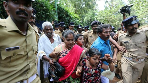 Police escort Madhavi and her family after they were heckled by protesters, who stopped them from entering the Lord Ayyappa temple in Sabarimala, Kerala, on Wednesday.(Vivek Nair/HT Photo) Police escort Madhavi and her family after they were heckled by protesters, who stopped them from entering the Lord Ayyappa temple in Sabarimala, Kerala, on Wednesday.(Vivek Nair/HT Photo)