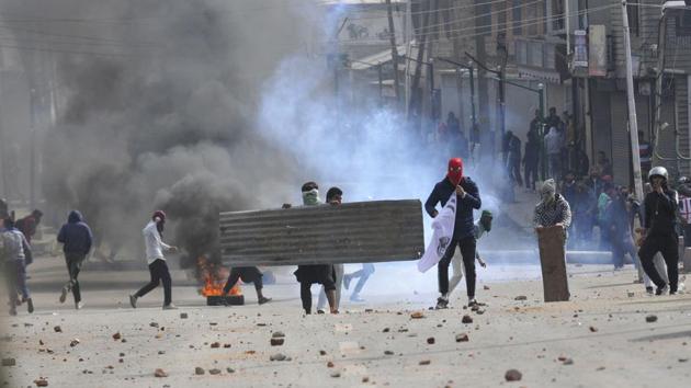 Protesters clash with police and paramilitary soldiers near the site of a gun battle between security forces and militants in downtown Srinagar. Two militants were among four people killed in an encounter. The slain militants, Mehraj Bangroo, Fahad Mushtaq Waza were associated with Lashkar-e-Taiba, police said. (Waseem Andrabi / HT Photo)