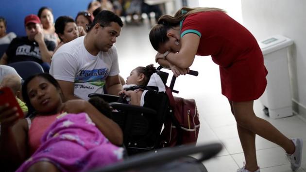 Gleyse Kelly da Silva, 28, rests on the baby carriage of her two-year-old daughter Maria Giovanna, while waiting for a medical appointment. “People do not respect my daughter’s rights,” she said. Other mothers have told her similar stories, including a bus passenger who refused to ride with “that demon,” referring to a baby with microcephaly. (Ueslei Marcelino / REUTERS)