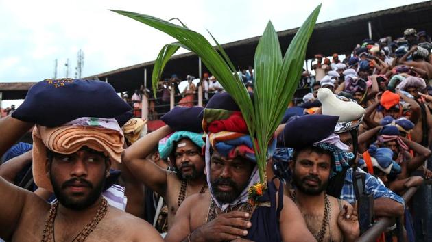 A Hindu devotee holds a coconut plant as he waits with others in queues inside the premises of the Sabarimala temple in Pathanamthitta district in Kerala, October 18, 2018 (REUTERS) A Hindu devotee holds a coconut plant as he waits with others in queues inside the premises of the Sabarimala temple in Pathanamthitta district in Kerala, October 18, 2018 (REUTERS)