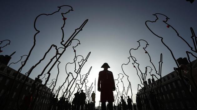A Chelsea Pensioner, in his ceremonial uniform as a retired member of the British army and resident of the Royal Hospital Chelsea retirement and care home, poses with 6 foot ‘Tommy’ figures at the Royal Hospital Chelsea in London, for the 'There But Not There' campaign to commemorate the upcoming centenary of the end of World War I. (Matt Dunham / AP)