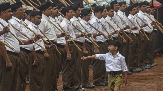 A boy walks past as volunteers of Rashtriya Swayamsevak Sangh (RSS) stand before 'Path Sanchalan' (route march) on Vijyadashmi festival at Shukrawar Peth on Thursday. (Pratham Gokhale/HT Photo) A boy walks past as volunteers of Rashtriya Swayamsevak Sangh (RSS) stand before 'Path Sanchalan' (route march) on Vijyadashmi festival at Shukrawar Peth on Thursday. (Pratham Gokhale/HT Photo)