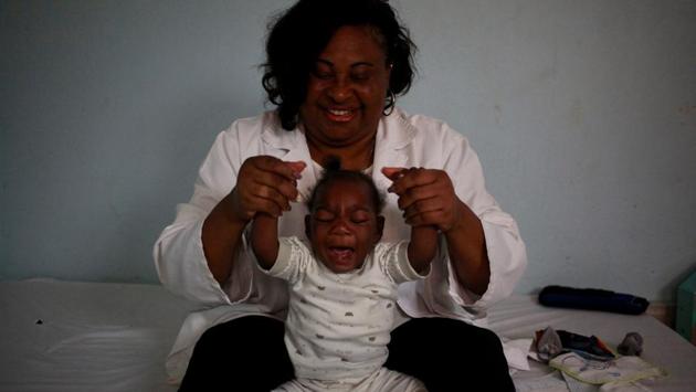 Ten month old Emiliano Cula, who has microcephaly, receives physiotherapy to try and stimulate control over his muscles in Luanda, Angola. (Stephen Eisenhammer / REUTERS)
