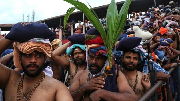 A Hindu devotee holds a coconut plant as he waits with others in queues inside the premises of the Sabarimala temple in Pathanamthitta(Reuters)