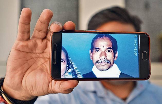 A man shows the photograph of his grandfather who was suffering from Alzheimer's disease and has been missing for years.(Sonu Mehta/ Hindustan Times)