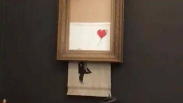 Banksy’s painting “Girl with Red Balloon” is seen shredded after its sale at Sotheby auction in London, Britain October 5, 2018.(INSTAGRAM/@PIERREKOUKJIAN/INSTAGRAM/@SINCEFINEART via REUTERS)