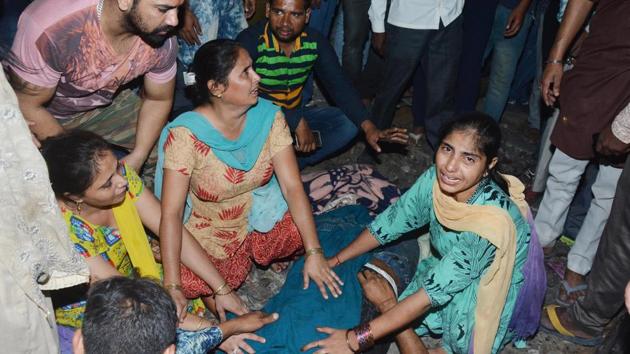 Relatives crying near the body of a young victim at the accident site at Jaura Phatak in Amritsar on Friday. Tragedy struck at a Dussehra celebration in Amritsar on Friday when a speeding train ran over a festive crowd that spilled on to the tracks while watching the customary burning of a giant Ravana effigy. At least 61 people were killed and 95 injured in the accident, according to a senior government official. (Sameer sehgal/ht )
