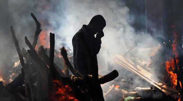 A man cries as he stands next to the burning pyre of a family member who died after a train travelling at high speed ran through a crowd of people on the rail tracks on Friday, at a cremation ground in Amritsar, October 20, 2018.(REUTERS)