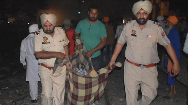 Police rescue the dead bodies kept on the railway track. Hundreds of people had gathered at an open ground near the manned crossing at Jaura Phatak, barely 70 metres from the Amritsar-Jalandhar double railway track where the celebrations were happening at around 7:15pm. (Sameer sehgal/ht )