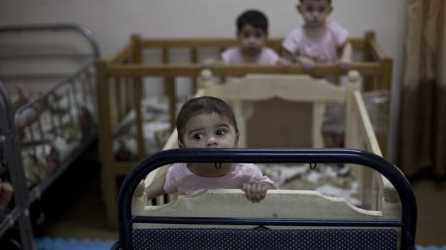 During a recent visit by The Associated Press, more than a dozen cribs were arranged end-to-end in a room set for babies. Toddlers able to stand rocked side to side, holding the sides of the cribs. There were plenty of cuddles by staff, who left no baby to cry. (Maya Alleruzzo / AP) 