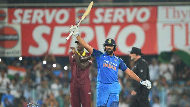 Indian batsman Rohit Sharma raises his bat after completing his century. (AFP)