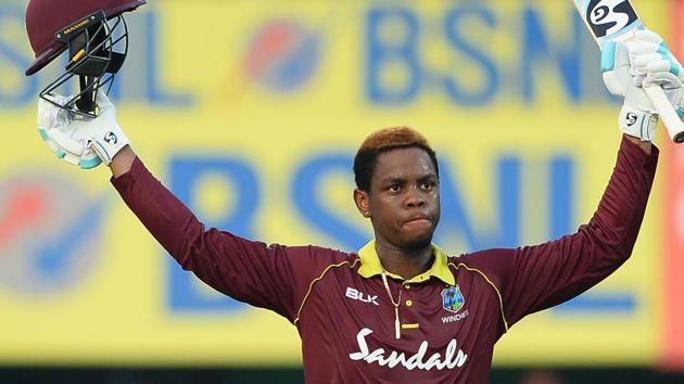 West Indies batsman Shimron Hetmyer raises his bat and helmet after he completed his century. (AFP)