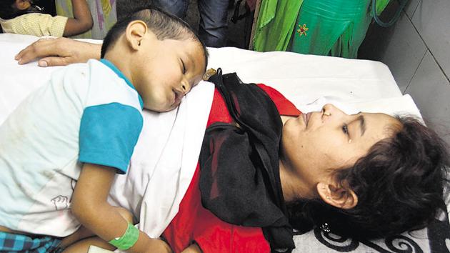 A boy, Arush, with his mother Preeti, one of 43 injured, who are being treated at the Guru Nanak Dev Hospital.(Sameer Sehgal/HT Photo)