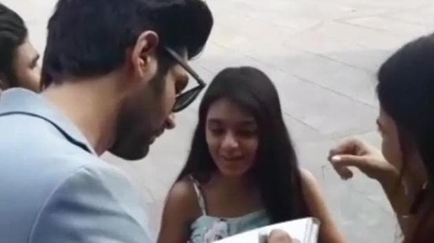 Kartik Aaryan signs an autograph for his young fan.(Viral Bhayani)