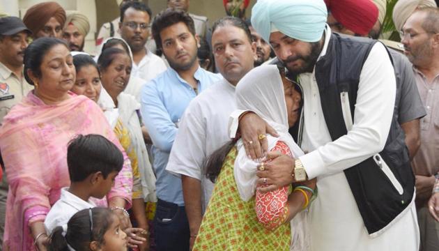 Punjab local Bodies Minister Navjot Singh Sidhu with the family member of those who lost their lives in the train tragedy during giving cheques of compensation at circuit house in Amritsar on Monday. (HT Photo) Punjab local Bodies Minister Navjot Singh Sidhu with the family member of those who lost their lives in the train tragedy during giving cheques of compensation at circuit house in Amritsar on Monday. (HT Photo)