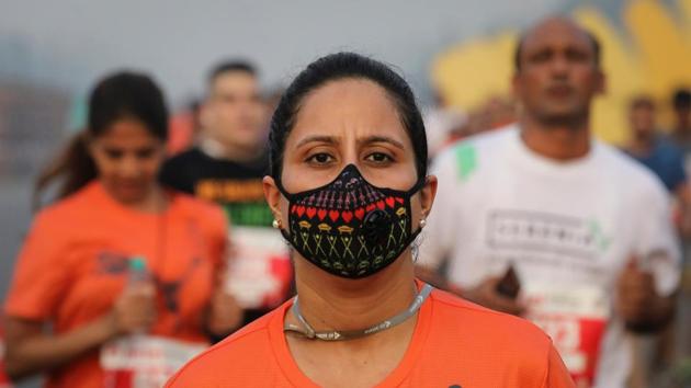A runner wearing a face mask for protection from air pollution takes part in the Airtel Delhi Half Marathon in New Delhi.(REUTERS)