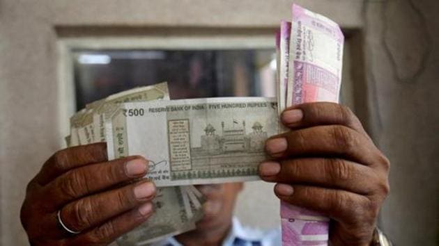 A cashier checks rupee notes inside a room at a fuel station in Ahmedabad on September 20.(REUTERS)