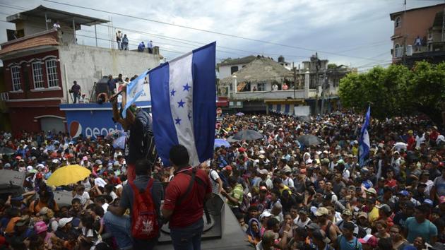 Honduran migrants stream towards the border bridge in Tecun Uman on Friday, moments before they broke down the gates at the Guatemala-Mexico border crossing and began streaming into Mexico. The caravan’s numbers have continued to grow as they walk and hitch rides through hot and humid weather, and the UN estimates it currently comprises some 7,200 people. (Oliver de Roos / AP) Honduran migrants stream towards the border bridge in Tecun Uman on Friday, moments before they broke down the gates at the Guatemala-Mexico border crossing and began streaming into Mexico. The caravan’s numbers have continued to grow as they walk and hitch rides through hot and humid weather, and the UN estimates it currently comprises some 7,200 people. (Oliver de Roos / AP)