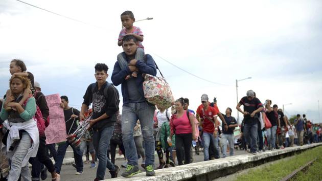 Honduran migrants rush across the border towards Mexico, in Tecun Uman, Guatemala. Thousands of Central American migrants continue an arduous trek toward the US border with many bristling at suggestions there could be terrorists among them and saying the caravan is being used for political ends by US President Donald Trump. (Oliver de Roos / AP) Honduran migrants rush across the border towards Mexico, in Tecun Uman, Guatemala. Thousands of Central American migrants continue an arduous trek toward the US border with many bristling at suggestions there could be terrorists among them and saying the caravan is being used for political ends by US President Donald Trump. (Oliver de Roos / AP)